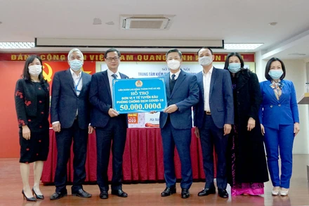Lãnh đạo Liên đoàn Lao động thành phố Hà Nội tặng quà Trung tâm kiểm soát bệnh tật thành phố. (Ảnh: LĐ)