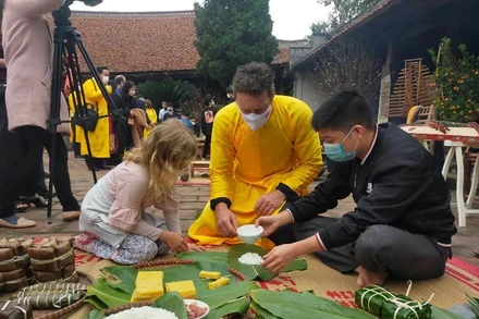 Khách quốc tế trải nghiệm gói bánh Chưng tại làng cổ Đường Lâm.