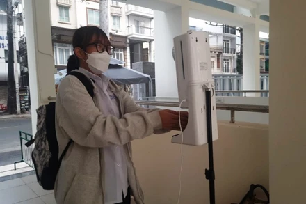 Học sinh khối 10 Trường THPT Bùi Thị Xuân, quận 1, TP Hồ Chí Minh đo thân nhiệt, sát khuẩn trước khi vào trường học.