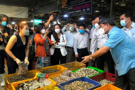 Thứ trưởng Nông nghiệp và Phát triển nông thôn Trần Thanh Nam (bên phải) trao đổi với tiểu thương chợ Bình Điền.