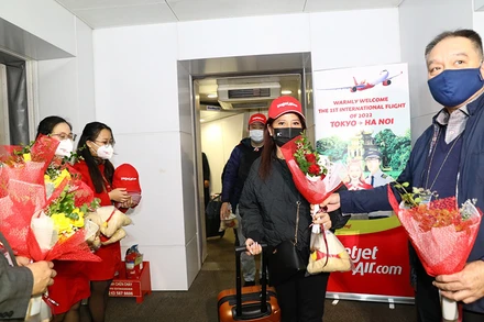 Lãnh đạo Cục Hàng không tặng hoa cho hành khách trên chuyến bay. (Ảnh: Hãng hàng không Vietjet cung cấp)
