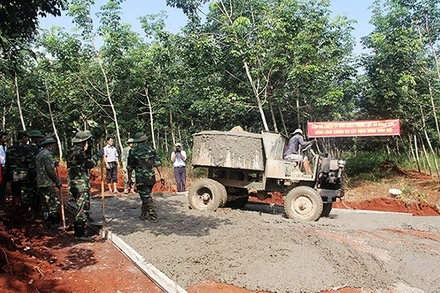 Bộ đội Biên phòng tỉnh Bình Phước phối hợp các lực lượng chức năng và người dân làm đường giao thông nông thôn tại xã Lộc Tấn, huyện Lộc Ninh. (Ảnh: HẢI ÐĂNG)