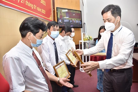 Phó Chủ tịch UBND tỉnh Kiên Giang Lê Quốc Anh (bên phải) trao bằng khen của UBND tỉnh cho các cá nhân.