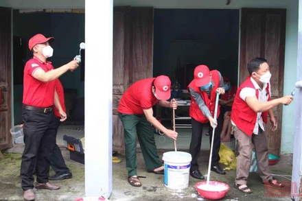 Các tình nguyện viên chữ thập đỏ sơn nhà cho các hộ gia đình khó khăn.