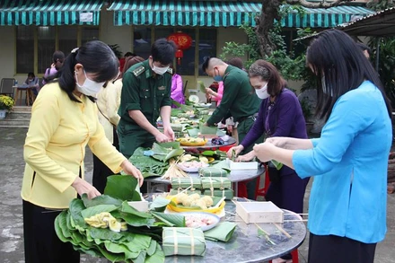 Cùng các chiến sĩ bộ đội biên phòng gói bánh chưng.