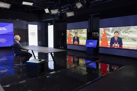 Nhà sáng lập kiêm Chủ tịch Điều hành WEF Klaus Schwab (bên trái) nghe Chủ tịch Trung Quốc Tập Cận Bình (ảnh màn hình) phát biểu tại Hội nghị trực tuyến WEF. (Ảnh: AP)