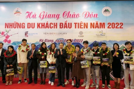 Lãnh đạo tỉnh Hà Giang tặng hoa và quà chúc mừng những vị khách đầu tiên.