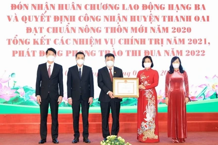 Phó Bí thư Thường trực Thành ủy Hà Nội Nguyễn Thị Tuyến trao quyết định công nhận huyện đạt chuẩn nông thôn mới năm 2020 cho lãnh đạo huyện Thanh Oai. (Ảnh: Ngọc Ánh)
