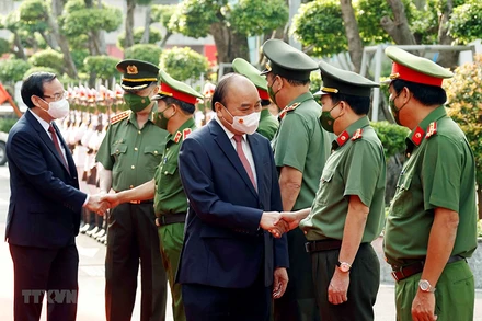 Chủ tịch nước Nguyễn Xuân Phúc, Bộ trưởng Công an Tô Lâm và Bí thư Thành ủy Thành phố Hồ Chí Minh Nguyễn Văn Nên với các lãnh đạo Công an Thành phố Hồ Chí Minh. (Ảnh: Thống Nhất/TTXVN)