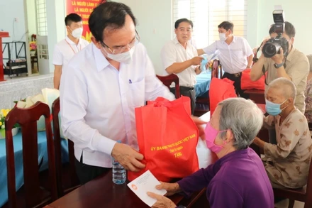 Đồng chí Nguyễn Văn Nên, Ủy viên Bộ Chính trị, Bí thư Thành ủy TP Hồ Chí Minh (bên trái) trao quà tặng người dân.