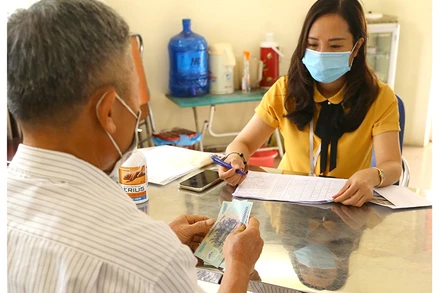 Chi trả hỗ trợ cho người bị ảnh hưởng bởi Covid-19 theo Nghị quyết 68 ở phường Thạch Bàn, quận Long Biên, Hà Nội (Ảnh: Hoàng Hiếu)