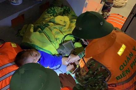 Các chiến sĩ quân y sơ cấp cứu và khẩn trương đưa ngư dân tai biến vào đất liền.