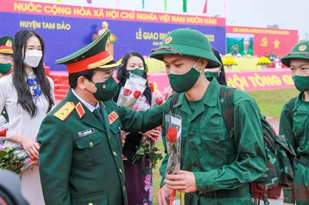 Phó Chủ nhiệm Tổng cục Chính trị Quân đội nhân dân Việt Nam Trịnh Văn Quyết tặng hoa các tân binh.