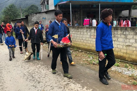 Đoàn lễ đang đi đến từng nhà để thực hiện lễ quét ma.