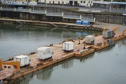 Các xe hàng được thông quan tại tại lối mở Cầu phao tạm km 3+4 Hải Yên-Cửa khẩu quốc tế Móng Cái. (Ảnh: TTXVN)