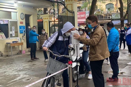 Kiểm tra thân nhiệt cho học sinh trước khi vào lớp tại Trường THPT Việt Đức (quận Hoàn Kiếm, Hà Nội).