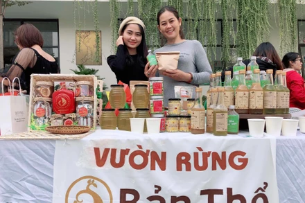 Ngọc Linh (bìa trái) giới thiệu sản phẩm của Vườn rừng Bản Thổ tại một phiên chợ nông nghiệp xanh.