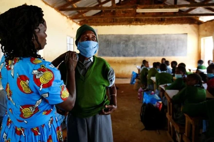 Cụ học sinh lớp 6 Priscilla Sitienei, 98 tuổi, được giáo viên chủ nhiệm Leonida Taalam giúp chỉnh lại đồng phục, Nandi, Kenya, ngày 25/1/2022. (Ảnh: REUTERS)