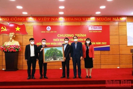 Tổng Biên tập Báo Nhân Dân Lê Quốc Minh trao bức tranh lưu niệm cho lãnh đạo tỉnh Lào Cai.