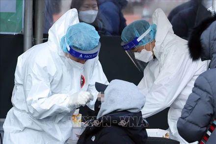 Nhân viên y tế lấy mẫu xét nghiệm Covid-19 cho người dân tại Seoul, Hàn Quốc, ngày 20/2. (Ảnh: Yonhap/TTXVN)