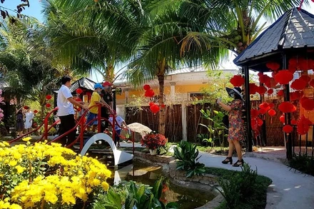 Du khách thích thú chụp ảnh lưu niệm tại làng du lịch Ông Đề.