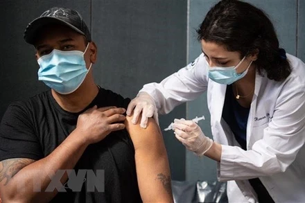 Nhân viên y tế tiêm vaccine phòng Covid-19 cho người dân tại New York, Mỹ. (Ảnh: AFP/TTXVN)