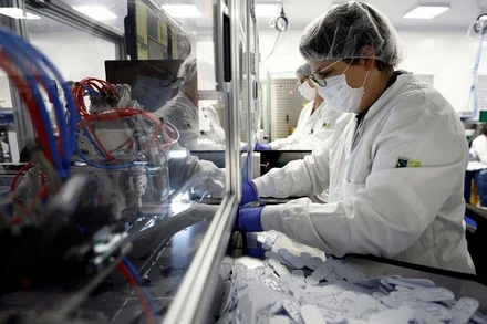 Nhân viên làm việc trên dây chuyền sản xuất bộ kit xét nghiệm Covid-19 tại nhà máy NG Biotech ở Guipry-Messac, Pháp, ngày 12/1/2022. (Ảnh: REUTERS)