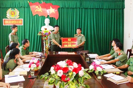 Thượng tá Nguyễn Thanh Tuấn trao số tiền 100 triệu đồng để hỗ trợ xây dựng nhà tình nghĩa cho cán bộ Công an huyện A Lưới có hoàn cảnh khó khăn.