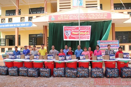 Đại diện Báo Giáo dục -Thời đại và lãnh đạo huyện Nậm Pồ trao quà cho giáo viên, học sinh bị ảnh hưởng bởi thiên tai.