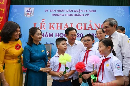 Đồng chí Vương Đình Huệ, Uỷ viên Bộ Chính trị, Bí thư Thành uỷ với các thầy cô giáo và các em học sinh Trường THCS Giảng Võ (Ảnh: DUY LINH)