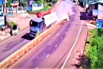 Chiếc xe cẩu sau khi đâm ô-tô bốn chỗ, tiếp tục cày nát 200m dải phân cách đường Hồ Chí Minh. (Hình ảnh từ camera an ninh của người dân ghi lại)