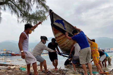 Lực lượng chức năng giúp người dân kéo tàu thuyền vào bờ, tránh bão số 5, sáng ngày 17-9.