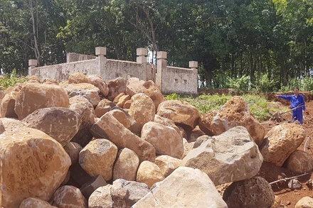 Đá bị múc lên ngổn ngang trước mặt tiền của di tích. 