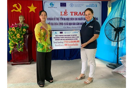 Trưởng đại diện UNWomen tại Việt Nam Elisa Fernandez Saenz (phải), trao tượng trưng tiền hỗ trợ cho người dân (Ảnh: UNWomen).