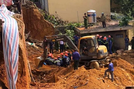 Lực lượng cứu hộ tìm kiếm công nhân bị vùi lấp. 