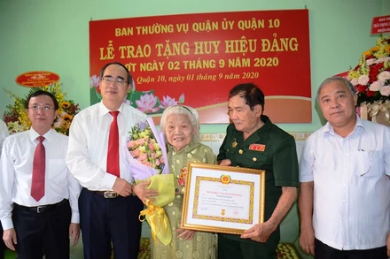 Đồng chí Nguyễn Thiện Nhân trao Huy hiệu 75 năm tuổi Đảng cho đồng chí Trần Thị Phát.