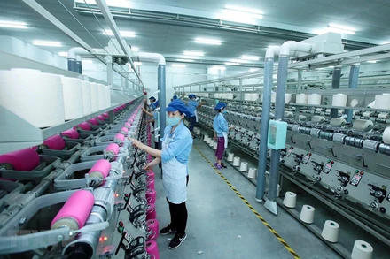 Công nhân sản xuất sản phẩm dệt nhuộm tại Công ty TNHH Dệt nhuộm Jasan Việt Nam. Ảnh: Phạm Kiên/TTXVN