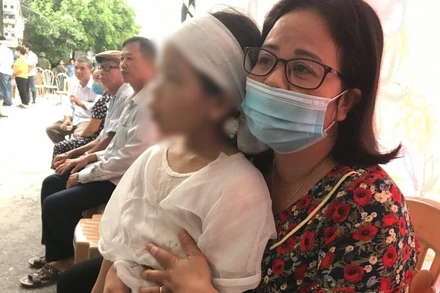 Chị Lương Thị Kiều Oanh, Chủ tịch Hội LHPN huyện Kiến Xương (tỉnh Thái Bình) bên cháu bé 6 tuổi (con nạn nhân Hương).