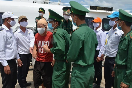 Cán bộ, chiến sĩ Bộ đội Biên phòng tỉnh Bình Thuận đón các ngư dân bị nạn được đưa từ Phú Quý vào đất liền ngay sau khi tàu cập cảng Phan Thiết.