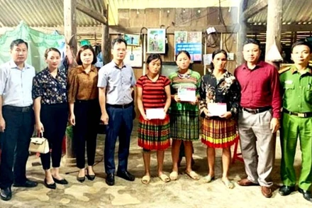 Lãnh đạo huyện ủy Văn Bàn và đoàn công tác trao sổ tiết kiệm cho gia đình nạn nhân vụ sập cổng trường học ở địa phương. 