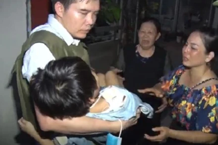 Lực lượng chức năng giải cứu bé gái bị bố đẻ bạo hành. (Ảnh: congan.com.vn)