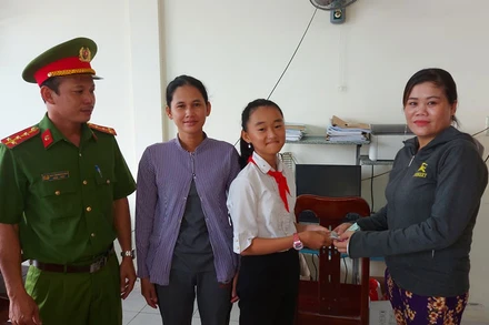 Em Nguyễn Thị Như Ý trao trả số tiền gần 14 triệu đồng cho người đánh rơi. (Ảnh: VŨ CHIẾN).