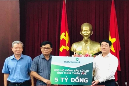 Thay mặt Vietcombank, đồng chí Nghiêm Xuân Thành, Bí thư Đảng ủy, Chủ tịch HĐQT (ngoài cùng bên phải) trao số tiền 5 tỷ đồng ủng hộ đồng bào tỉnh Thừa Thiên Huế.