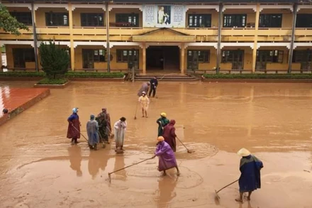 Dọn dẹp, vệ sinh trường lớp khi nước rút tại một ngôi trường trên địa bàn xã Sơn Trạch (Quảng Bình).