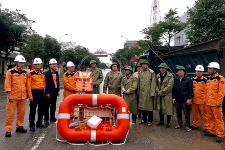 Phó Giám đốc Trung tâm MRCC Vũ Việt Hùng trao tặng áo phao, phao bè cứu sinh chuyên dụng cho người dân vùng lũ. 