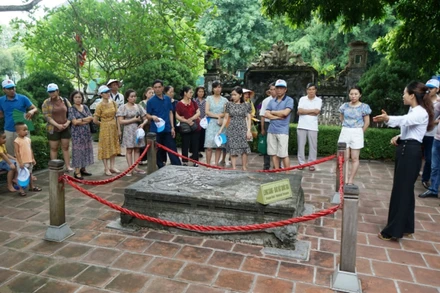 Khách du lịch tham quan “Long sàng” trước nghi môn ngoại đền vua Đinh.