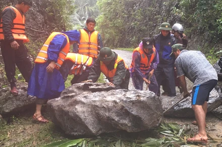 Bộ đội biên phòng Đồn Cà Xèng dùng sức để di chuyển từng tảng đá lớn lấy đường đi cho bà con 