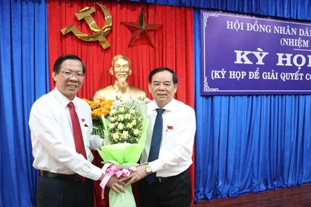 Đồng chí Phan Văn Mãi, Ủy viên T.Ư Đảng, Bí thư Tỉnh ủy (trái) tặng hoa chúc mừng đồng chí Trần Ngọc Tam.