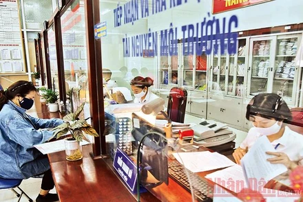 Cán bộ Bộ phận một cửa UBND quận Bắc Từ Liêm giải quyết thủ tục hành chính cho người dân. Ảnh minh họa: ANH VŨ