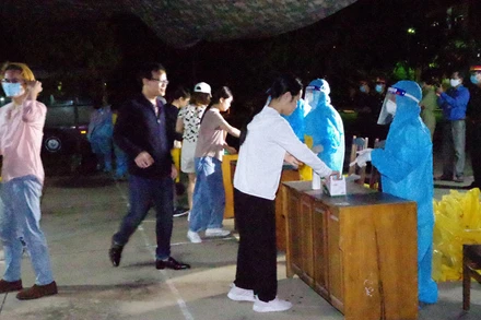 Các công dân nhận khẩu trang và làm thủ tục trước khi vào khu cách ly